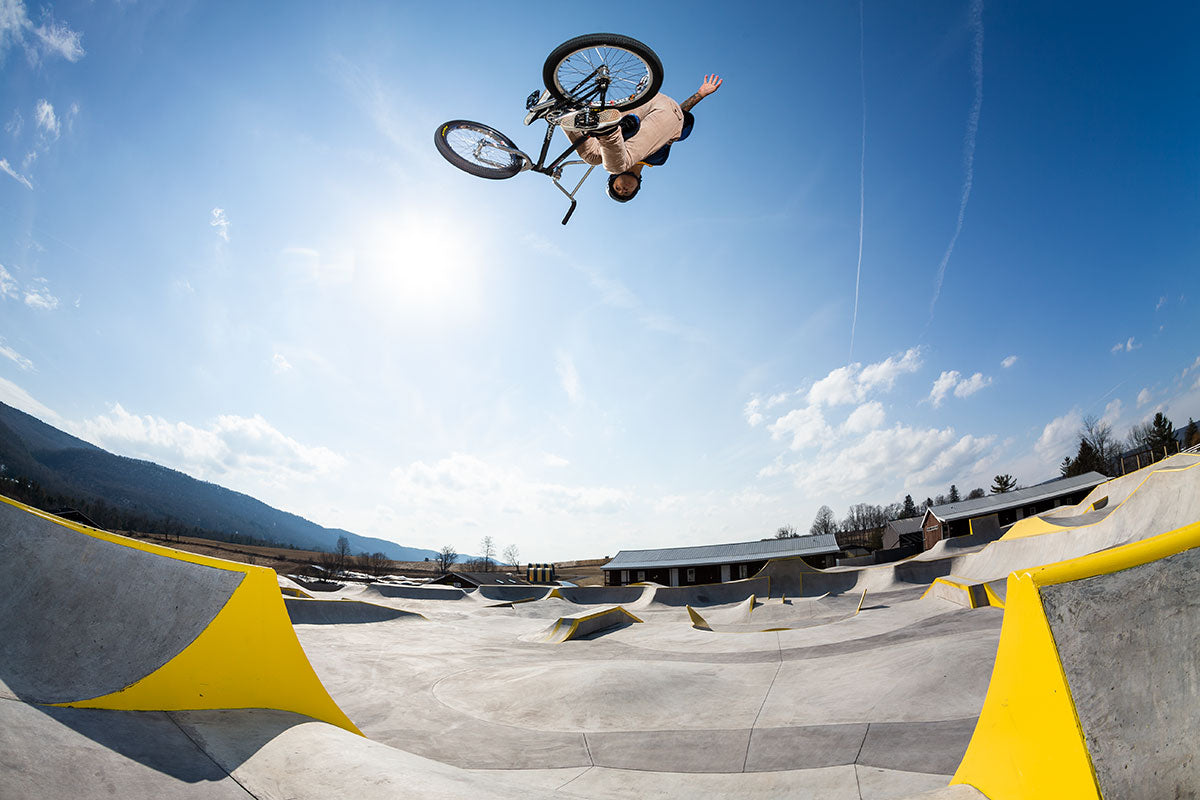 Boy on BMX in the air above BMX park